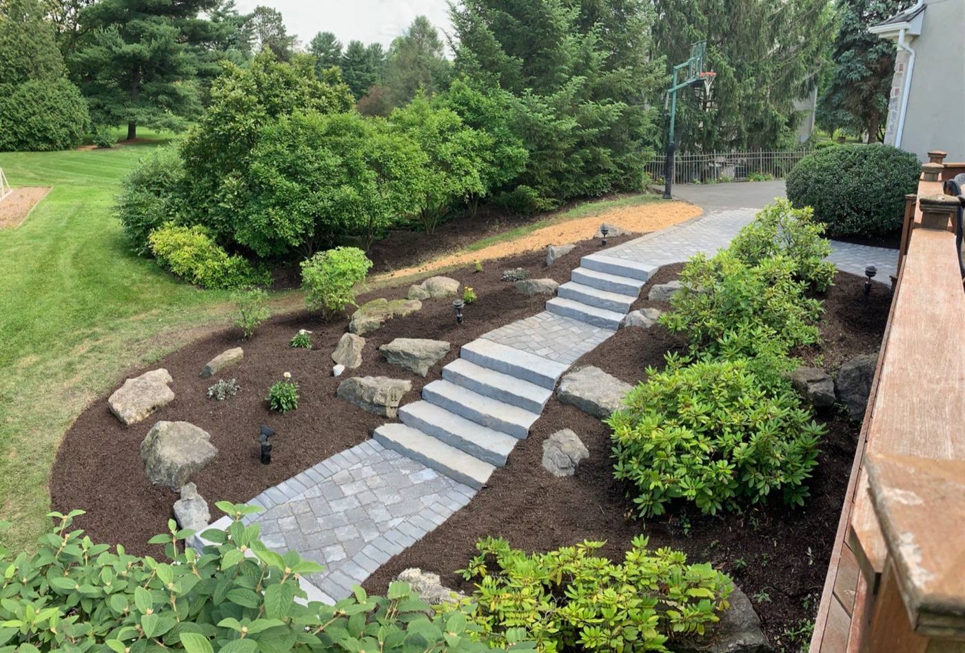 Stone steps and paver walkway through a planted slope